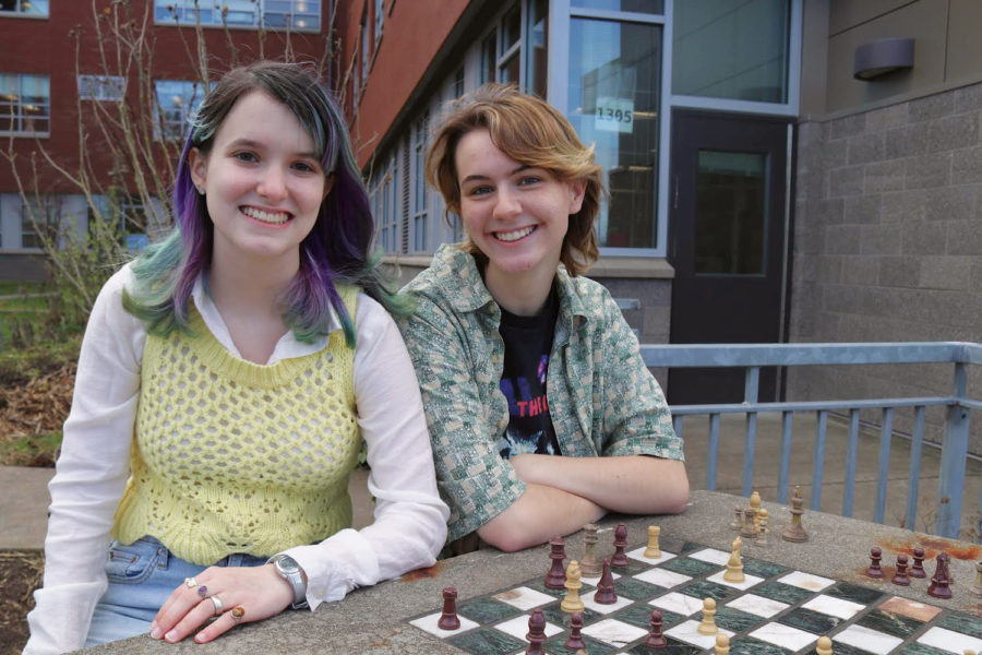 Eliana Megargee (left) and Darby ONeill (right), pose for a picture at the chess table in the Culinary Arts Garden